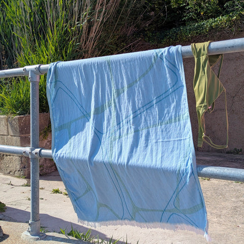 Laes Pool Turkish Towel - Beach Towel - blue and sage - hanging on a metal railing outdoors - shop now