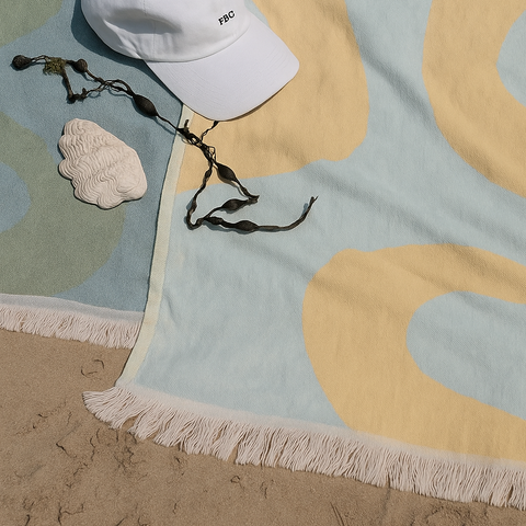 Laes Harbour Turkish Towels - Beach Towel - white cap on a colorful towel with sand and seaweed - shop now