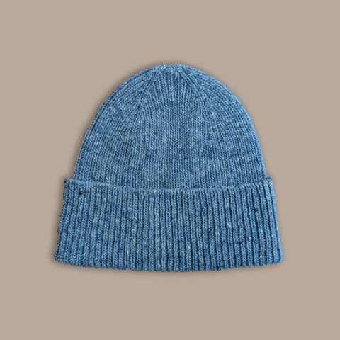 Blue knit beanie on a beige background
