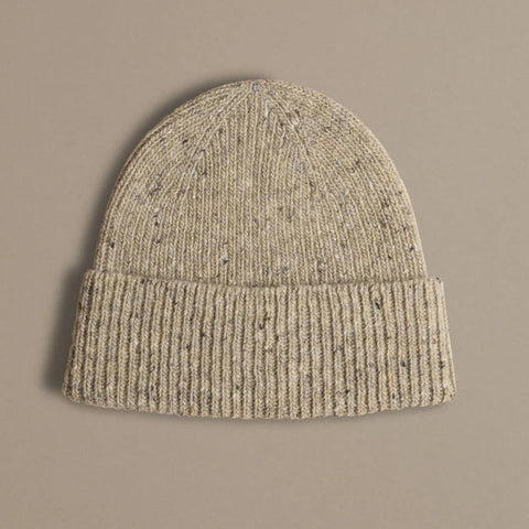 Beige knit beanie on a beige background