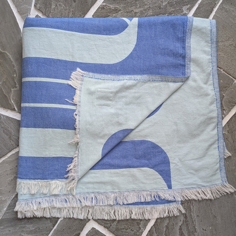 Blue and white striped blanket on a stone floor