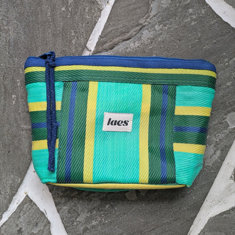 Striped pouch with a brand logo on a stone surface