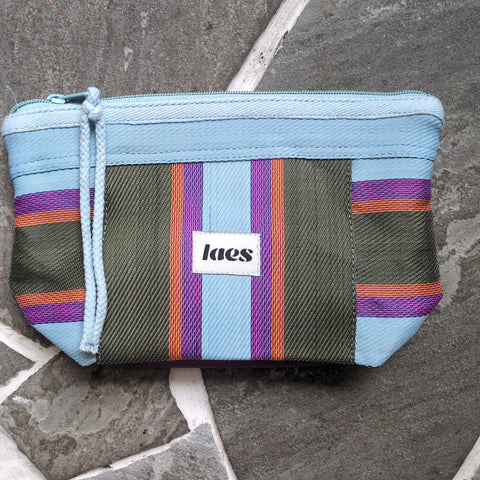 Multicolored striped pouch on a stone surface