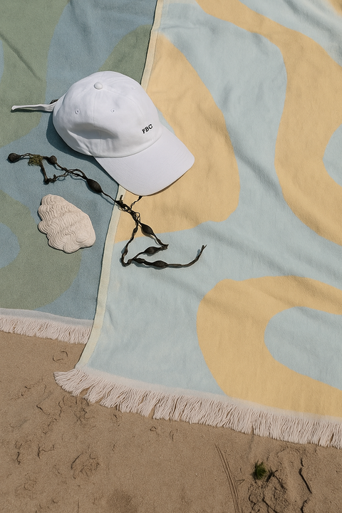 Laes Harbour Turkish Towels - Beach Towel - white cap on a colorful towel with sand and seaweed - shop now
