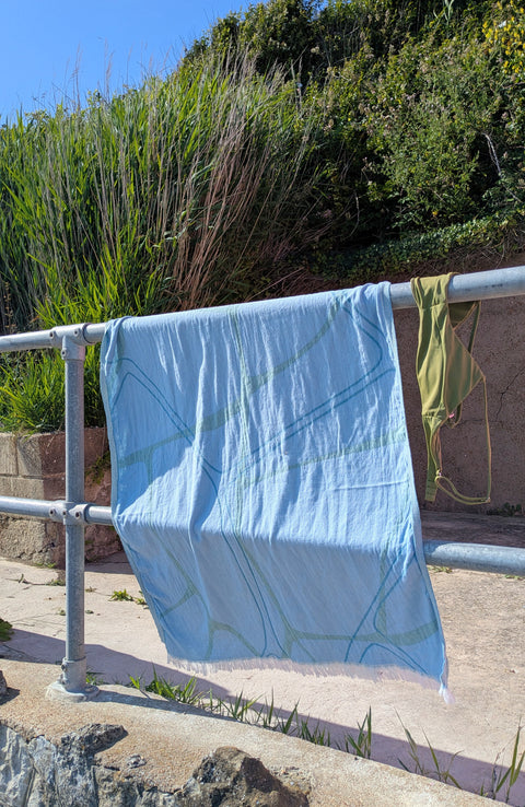 Laes Pool Turkish Towel - Beach Towel - blue and sage - hanging on a metal railing outdoors - shop now