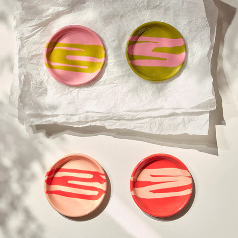 Set of colourful circular plates on a textured white surface