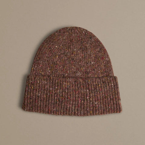 Rust coloured knitted beanie with multi coloured flecks on a white background