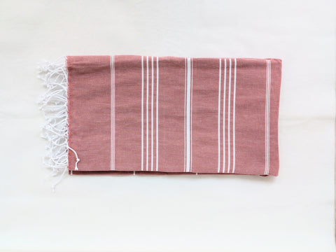 Brick-red striped towel with white stripes on a white background