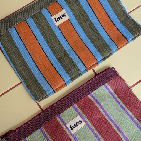 Two striped pouches with 'laes' branding on yellow tiles.