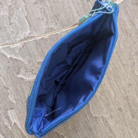 An open pouch showing a dark blue lining sat on a stone surface