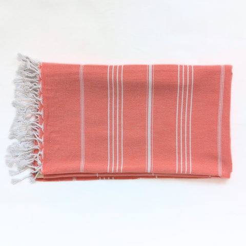 coral towel with white stripes on a white background