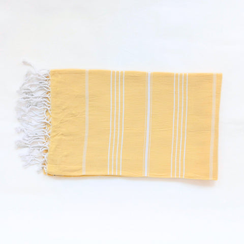Yellow towel with white stripes and fringes on a white background